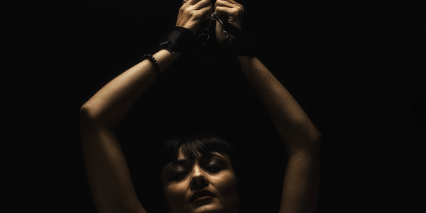 手を縛られて拘束される女性